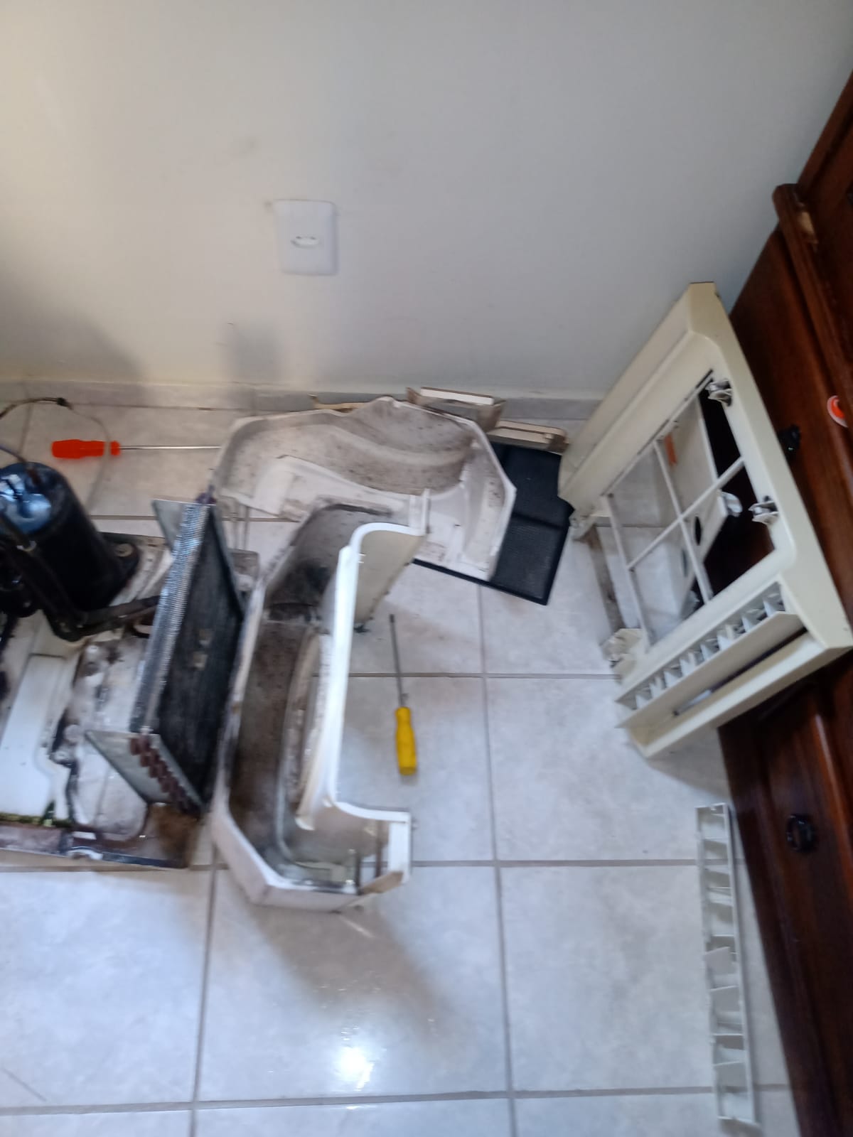 Peças do ar-condicionado separadas no chão durante a limpeza